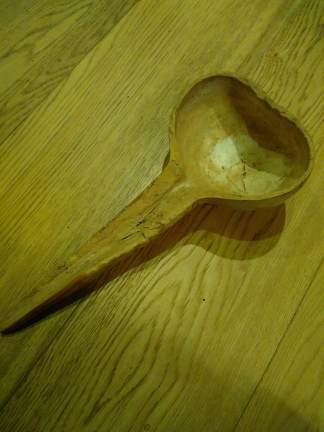 A serving spoon/ladle made by splitting a hard gourd in half - the thicker part of the gourd forms the bowl, the neck of the gourd forms the handle. Own photo.